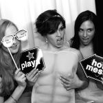 Three women posing for a photo in a photo booth.