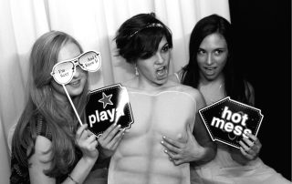 Three women posing for a photo in a photo booth.