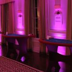 A room with purple lighting and a croupier table.