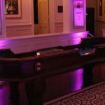 A billiard table in a room with purple lighting.