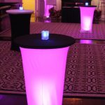 A table with purple lights in the middle of a room.
