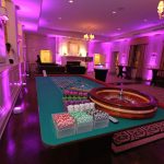 A casino table in a room with purple lighting.