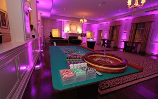 A casino table in a room with purple lighting.