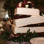 A white and burgundy wedding cake.