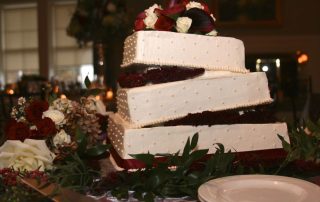 A white and burgundy wedding cake.