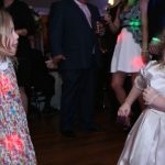 Two little girls dancing on the dance floor at a party.