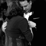 Black and white photo of a man hugging a woman.