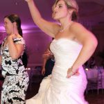 Two women dancing at a wedding reception.