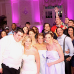A group of people posing for a photo at a wedding.