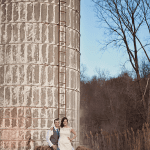 A bride and groom sitting in front of a silo.