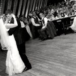 A bride and groom sharing their first dance in a barn.