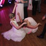 A bride and groom dancing on the floor at a wedding.