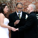 A bride and groom exchange vows in front of an audience.