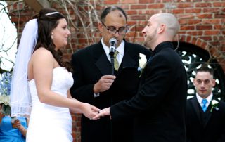 A bride and groom exchange vows in front of an audience.