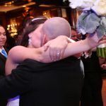 A bride and groom hugging each other at a wedding reception.