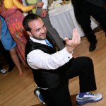 A man is dancing on the dance floor at a wedding.