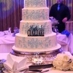 A white and blue wedding cake on a table.
