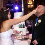 A woman feeding a man a cake.