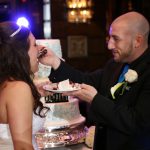 A bride and groom feeding each other a cake.