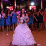 A bride in a blue dress standing on a dance floor.