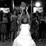 A bride is throwing her bouquet in the air at a wedding.