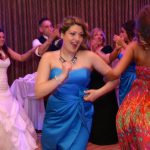 A woman in a blue dress dancing on the dance floor.