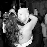 A bride and groom hugging during their first dance.