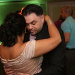 A man and woman hugging each other at a wedding reception.