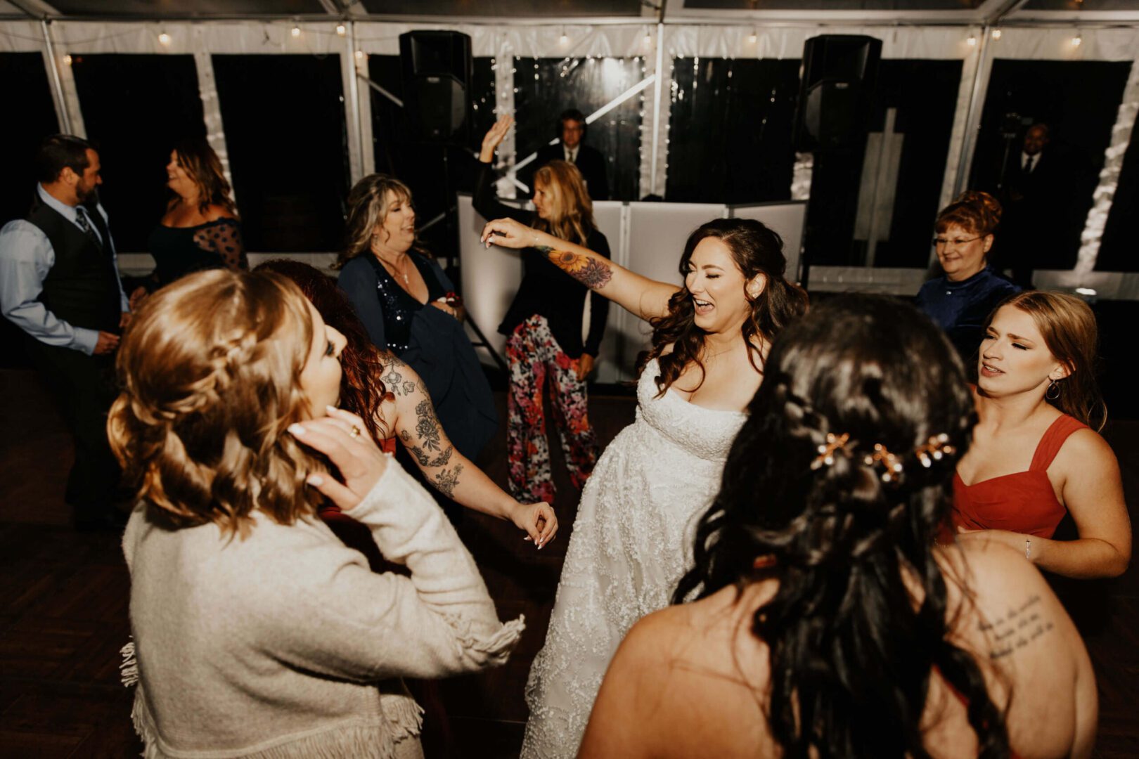 Bride dances with friends at wedding reception.