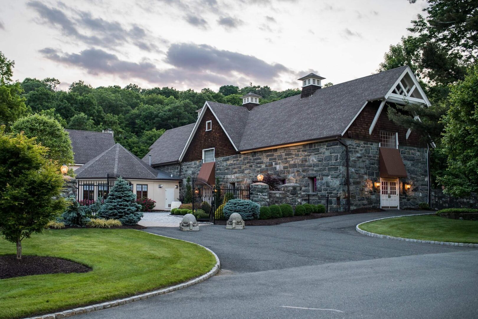 Stone house with a gated driveway.