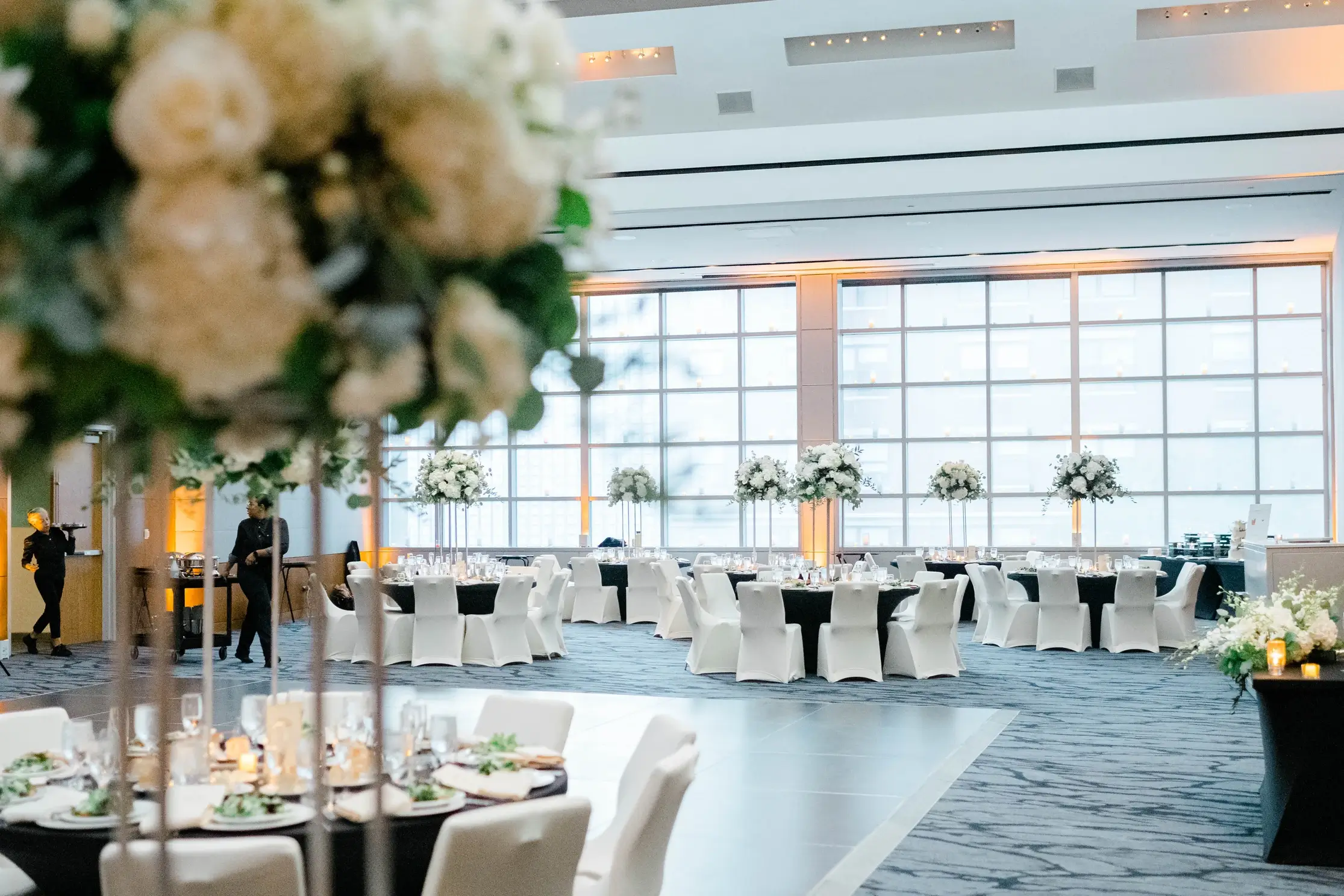 Wedding reception tables with white flowers.