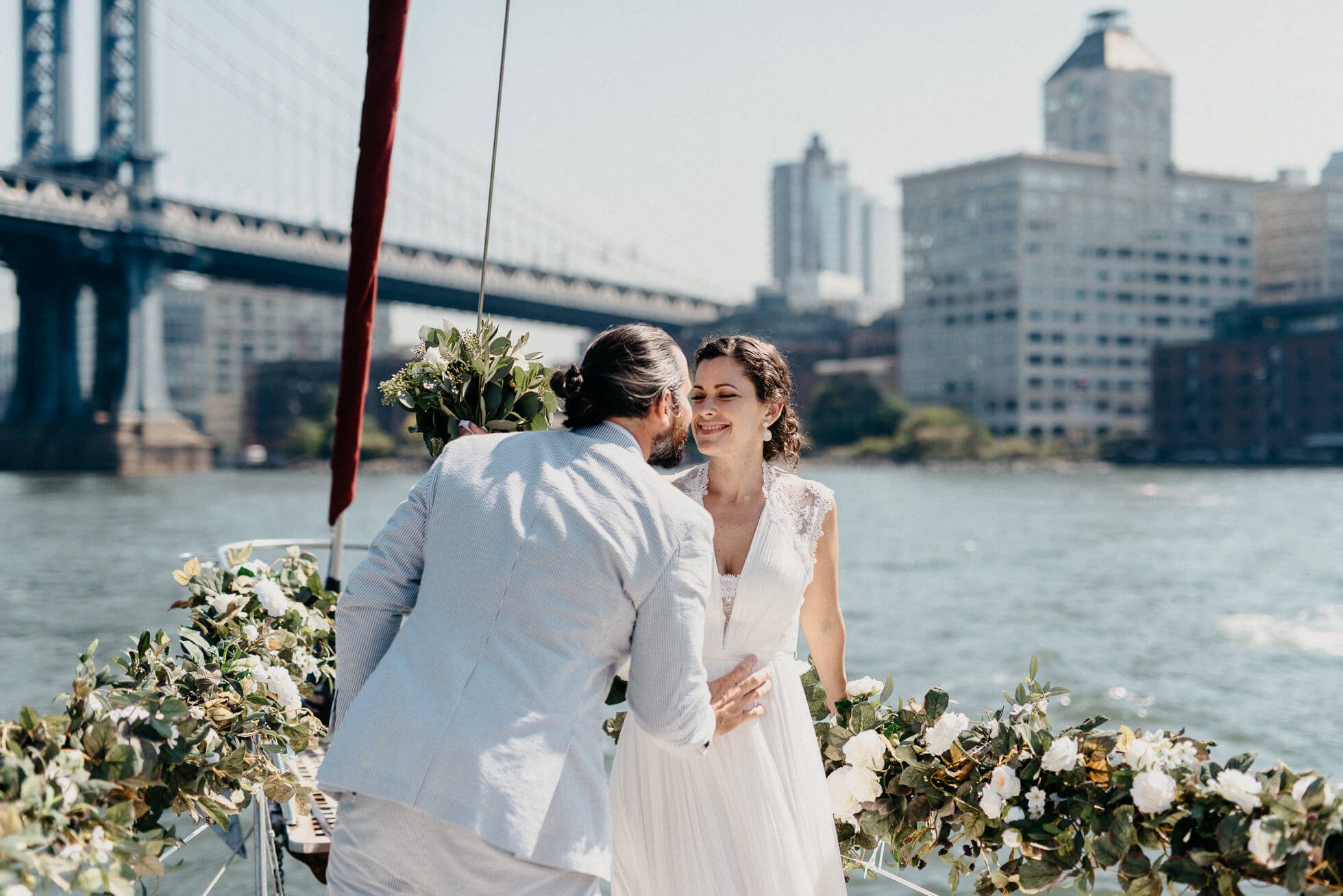 Bride and groom kiss on a boat.